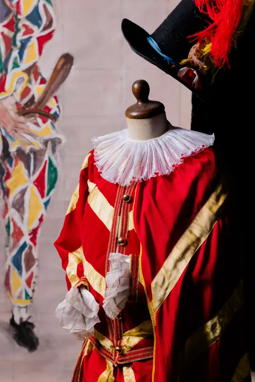 Costume da bambino in velluto rosso e raso oro con gorgiera bianca, su un piccolo manichino