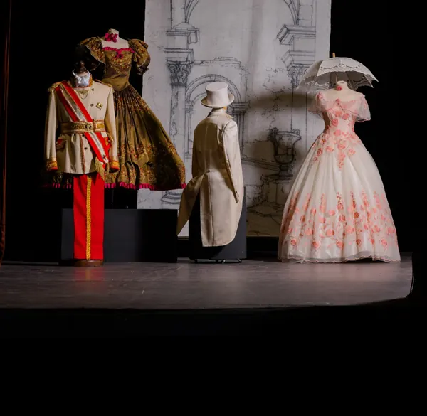 Costumi dell'Ottocento: uniforme bianca con fascia rossa, abito da ballo a fiori rosa, frac avorio con cilindro